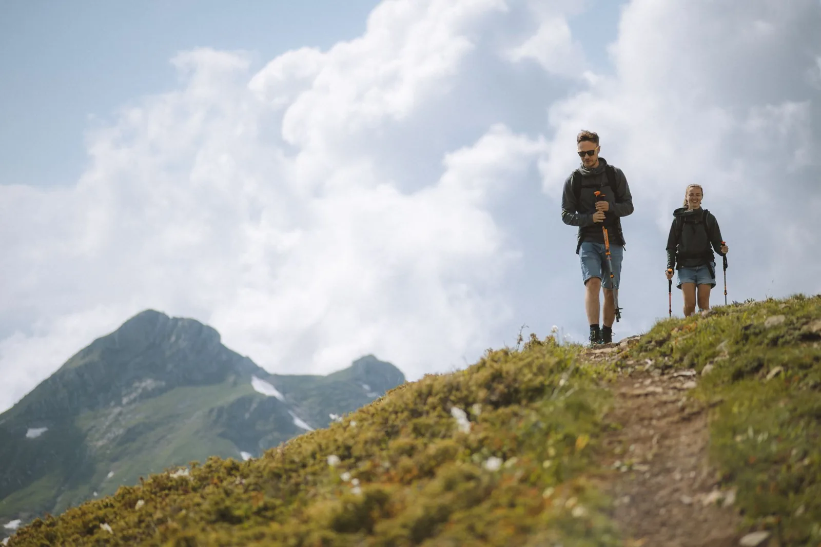 Young backpacker walking with a large camping pack on a coastal trail
